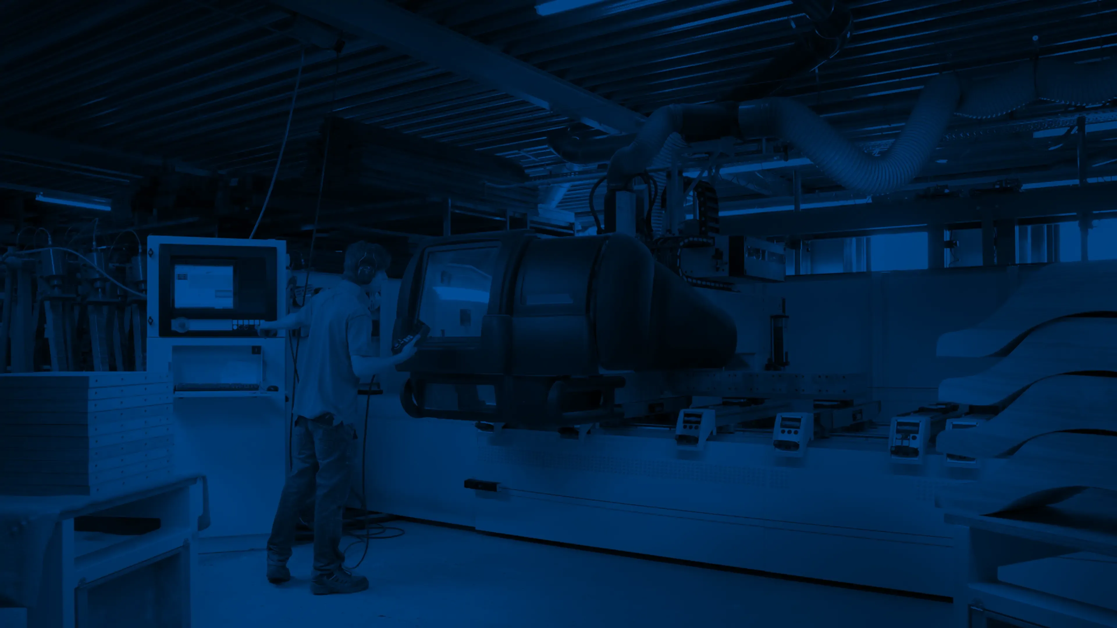 Un operatore alla consolle di un centro di lavoro CNC in officina.