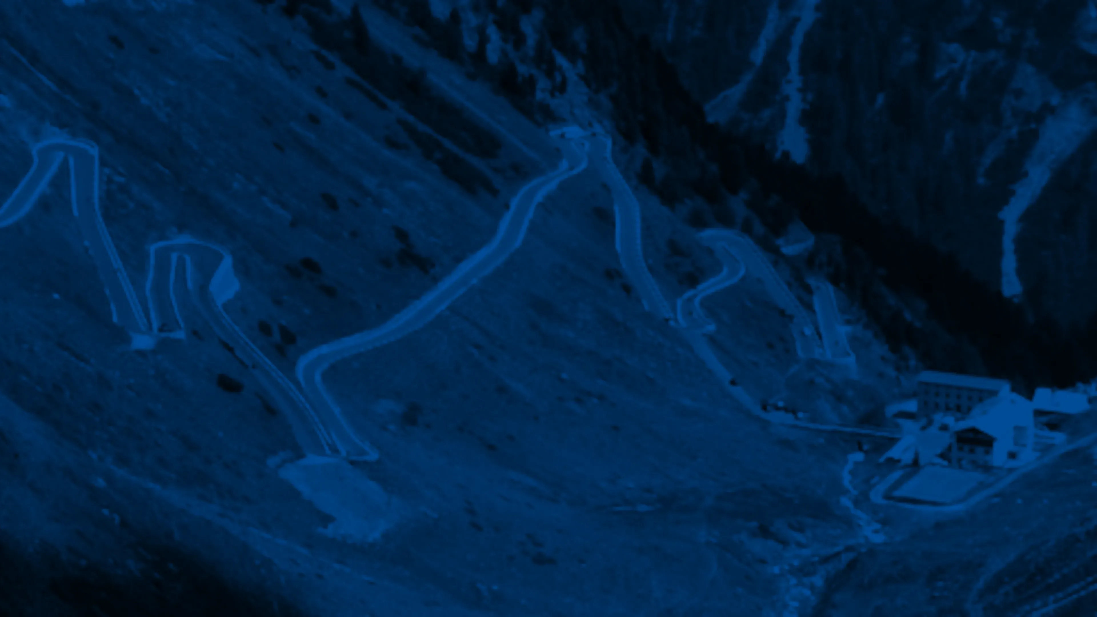 I tornanti di un passo alpino che risalgono il versante della montagna.